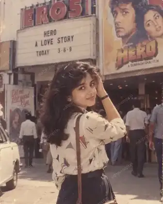 1980s cinema hall AI photo prompt - a woman outside a single-screen Bollywood theatre with a hand-painted film poster behind her